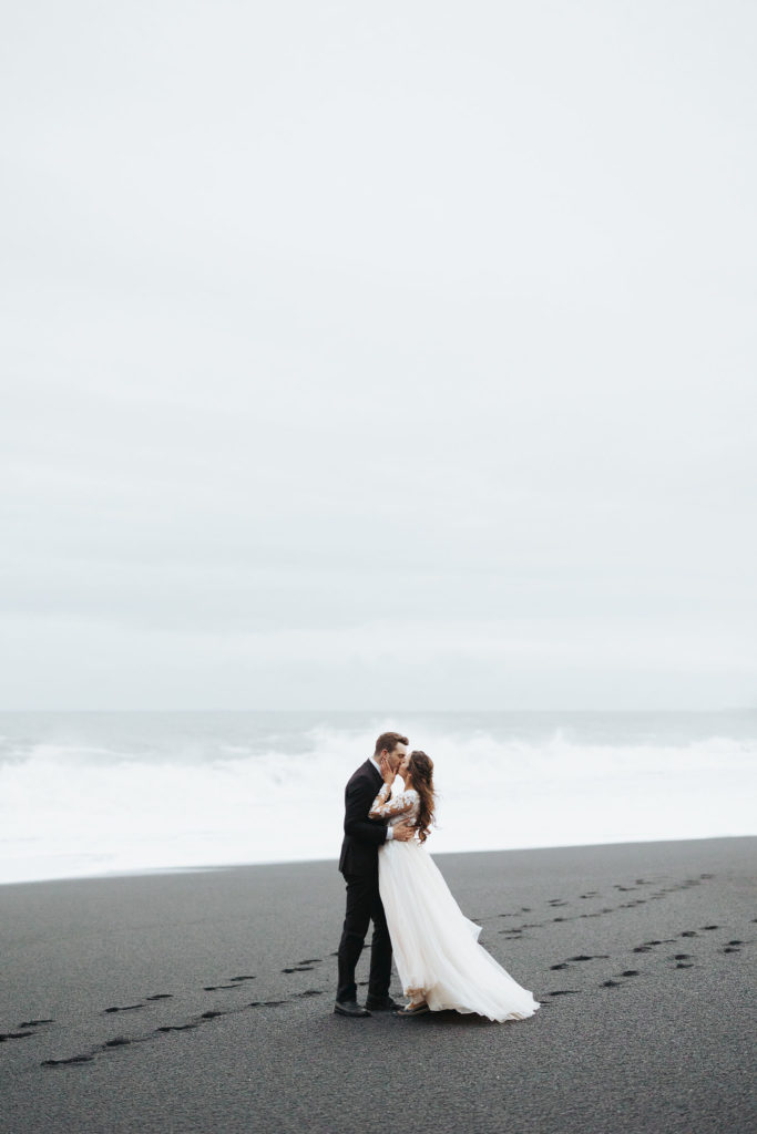 bride and groom on black sand beach iceland