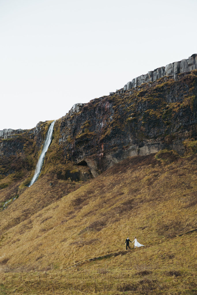 bride and groom on mountains and waterfall in iceland