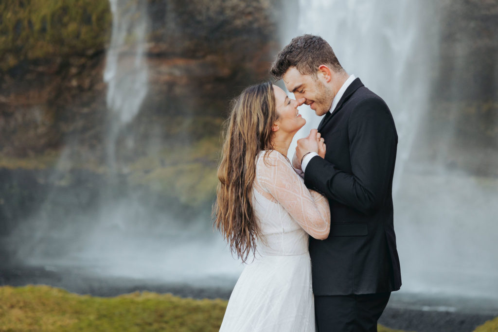 bride and groom elopement under waterfall in iceland