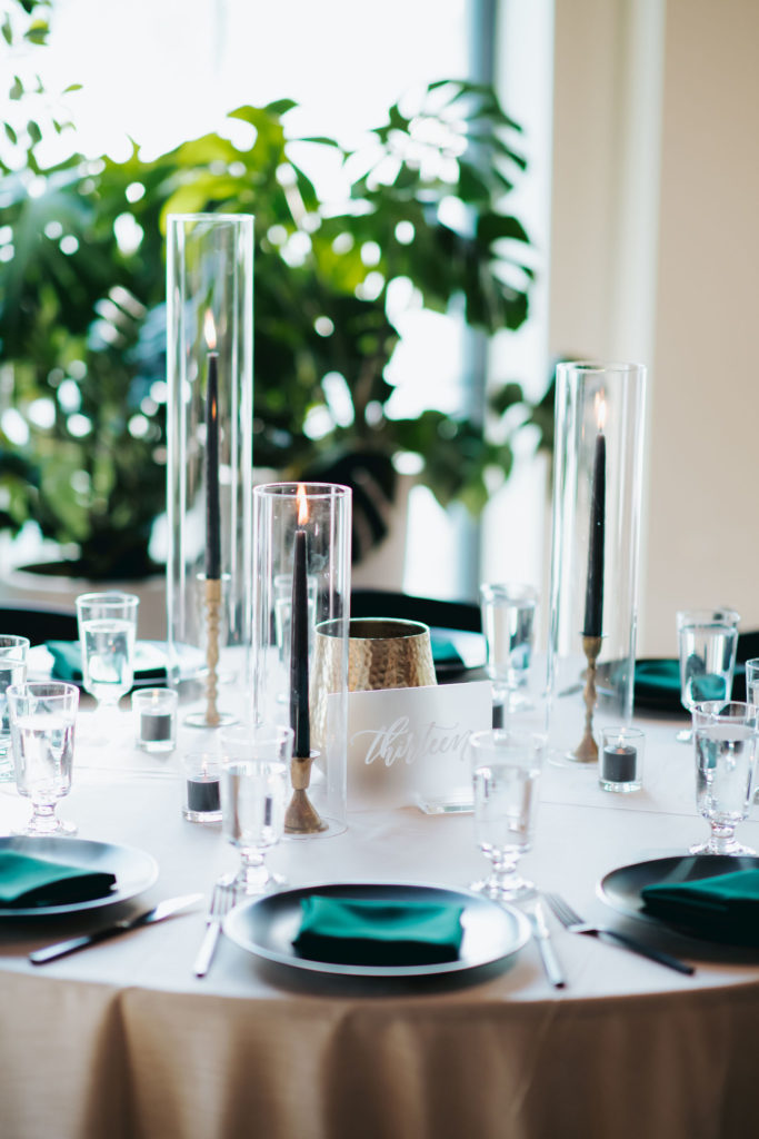 tall black candles in vases at wedding reception