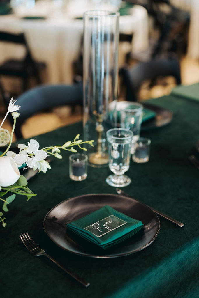 place settings at wedding reception on green velvet table cloth