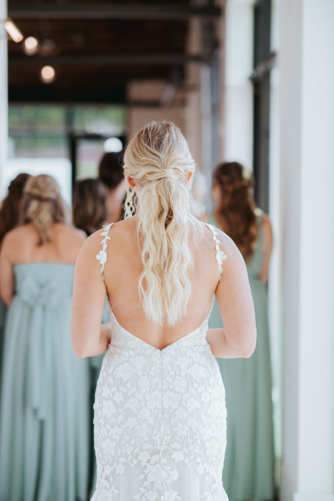 bride seeing her bridesmaids for the first time in wedding dress