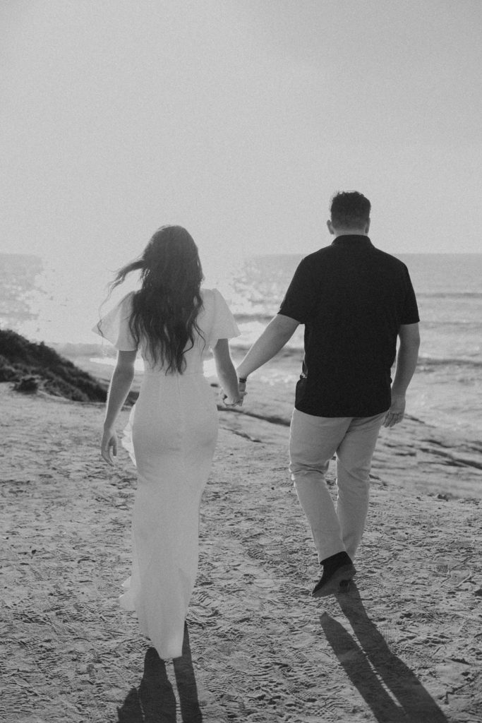 engaged couple walking on sunset cliffs in san diego