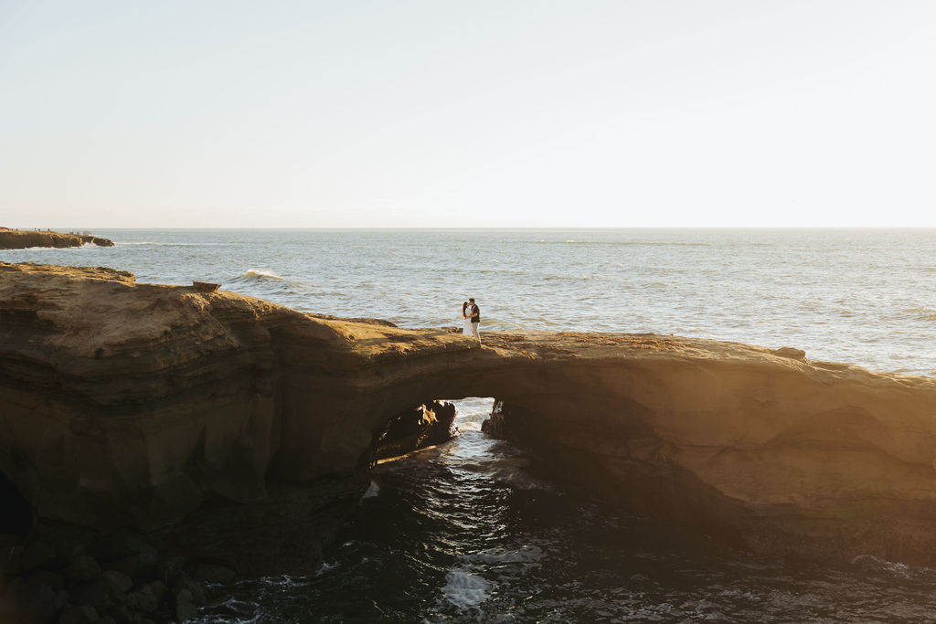 engaged couple kissing at sunset on san diego coast