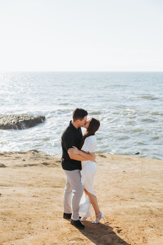 engaged couple kissing on san diego cliffs