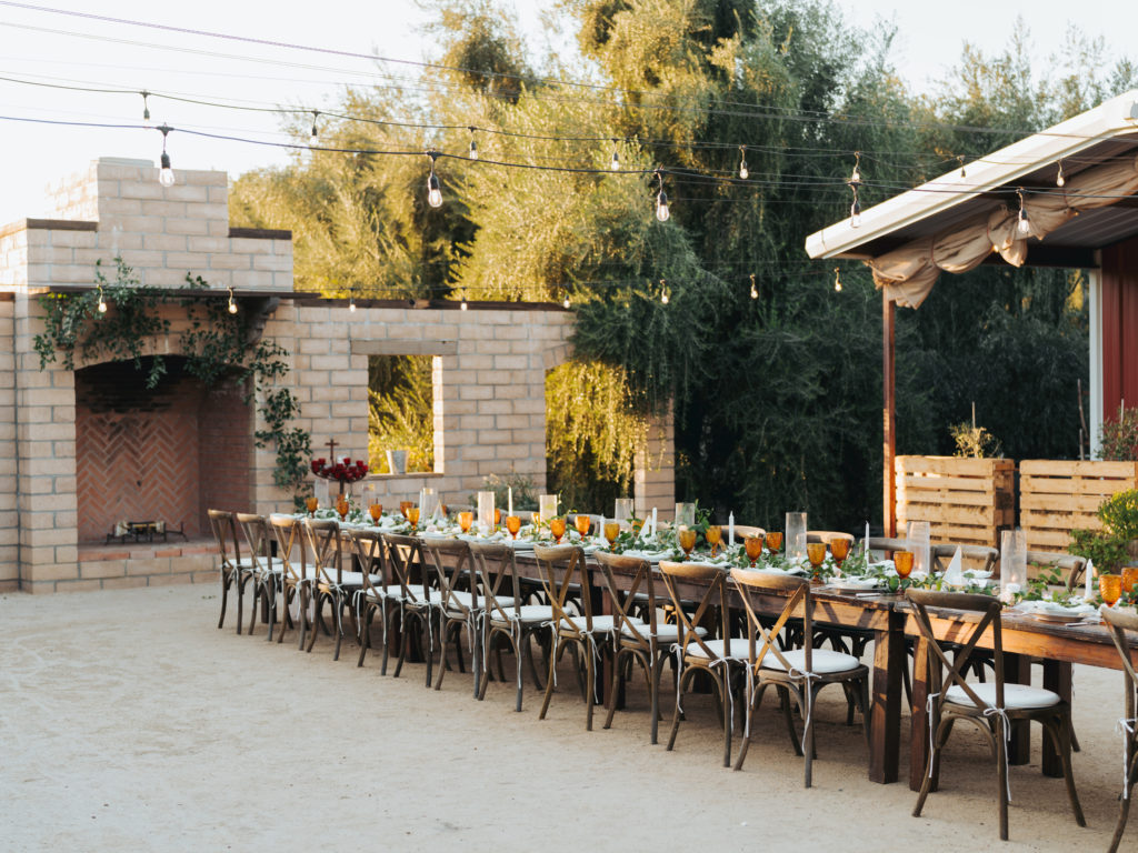 temecula wedding reception table with orange glass ware and white roses
