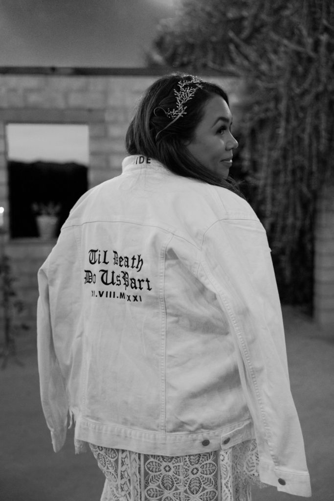 bride wearing denim jacket that says "til death do us part"