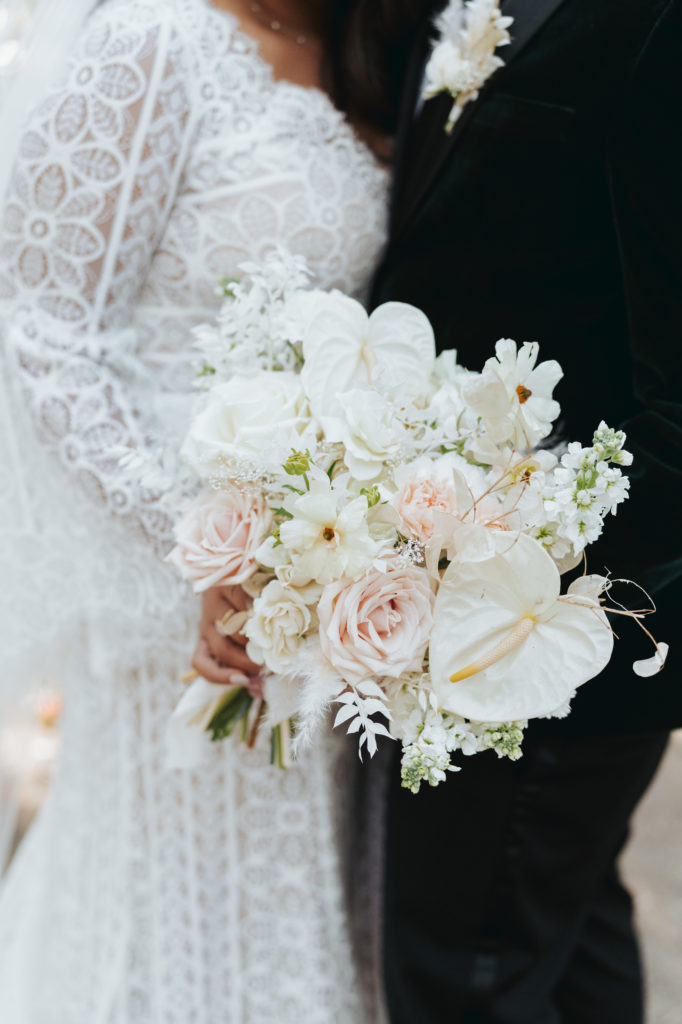 bride and groom holding white bouquet