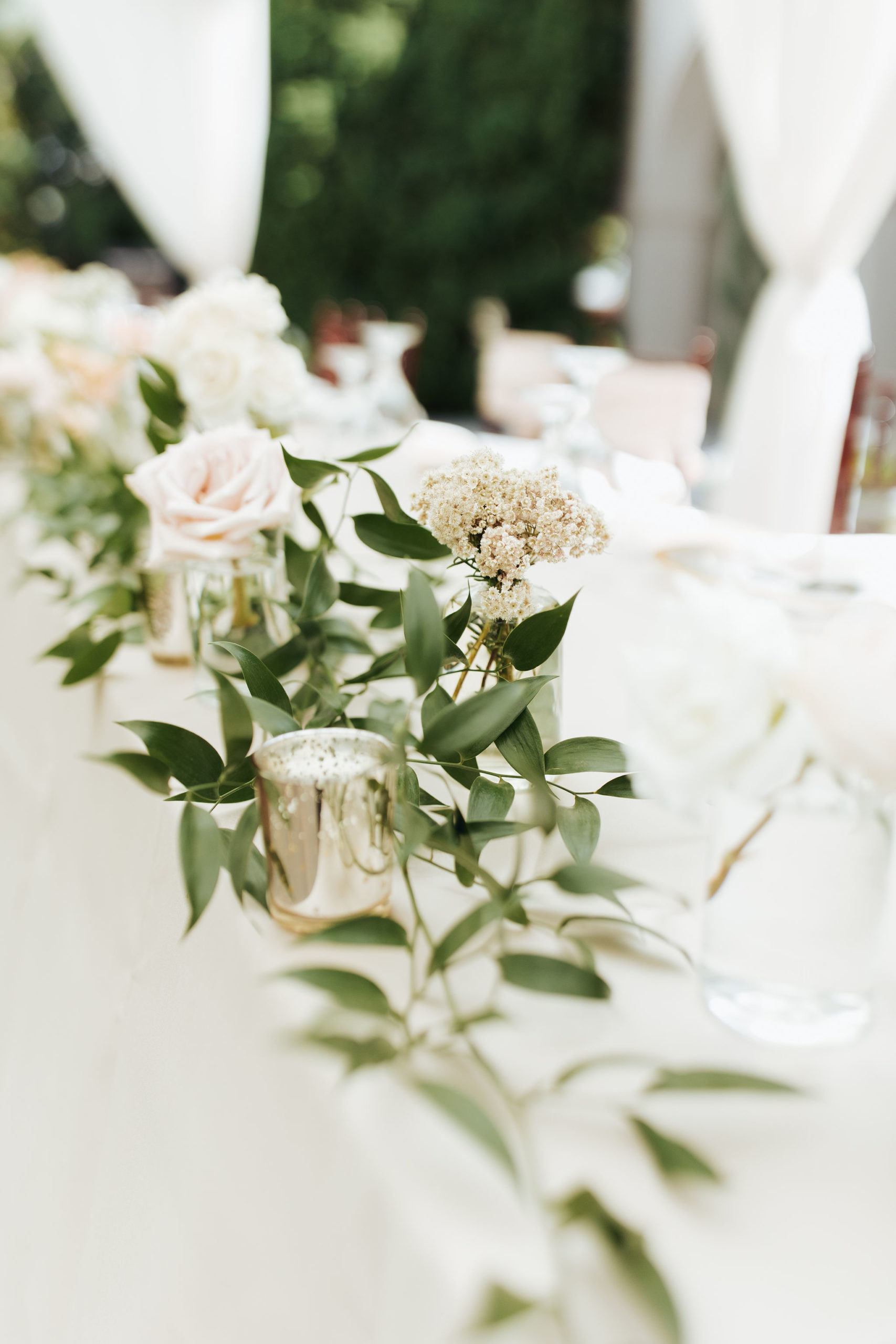 roses and greenery on reception tables