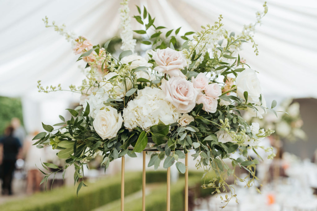 blush and cream wedding flowers on gold stand