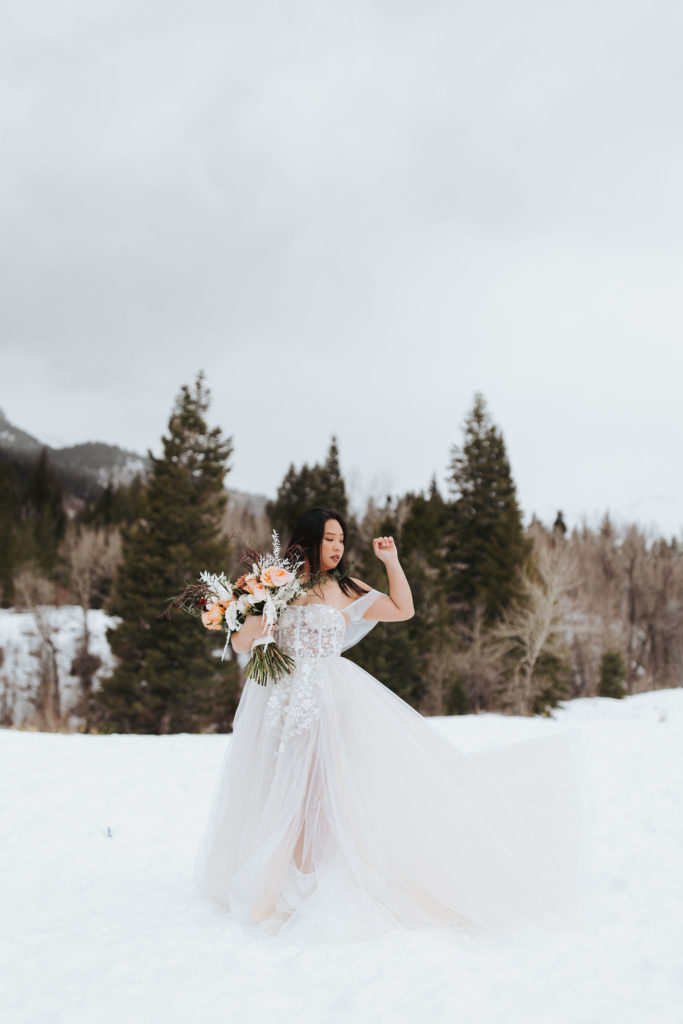 bridal portrait with bouquet on snowy mountain in utah