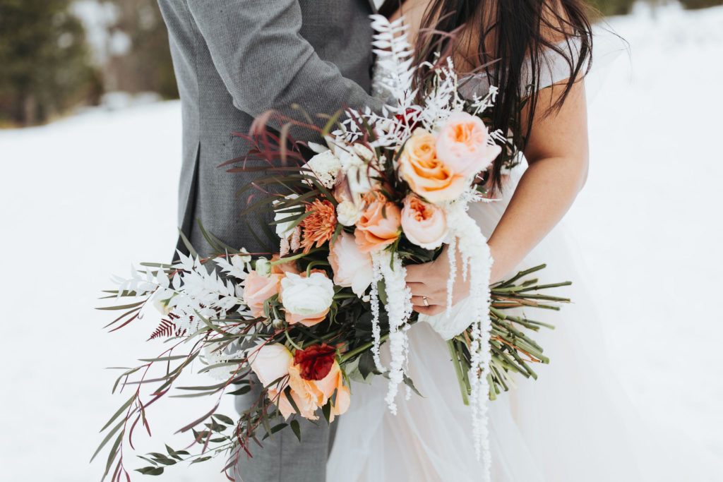 bride holding bouquet for snowy mountain elopement