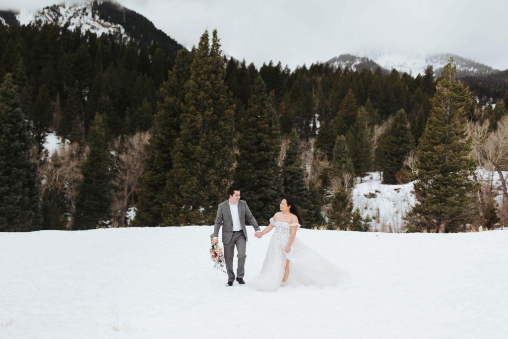 elopement couple walking in the snow in utah