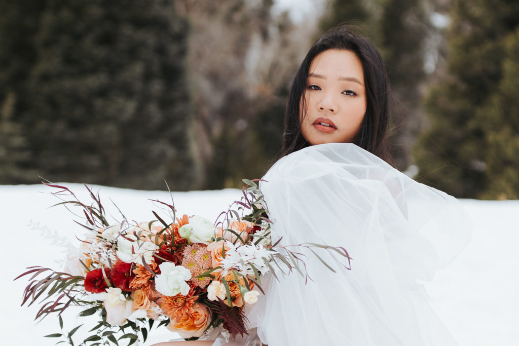 bridal portrait with bouquet on snowy mountain in utah