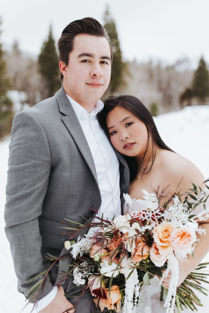 bride and groom on snowy mountain in utah