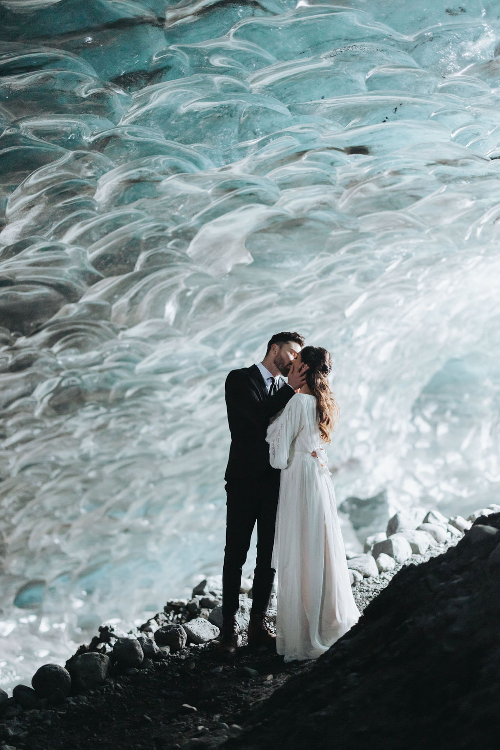 bride and groom kissing inside ice cave