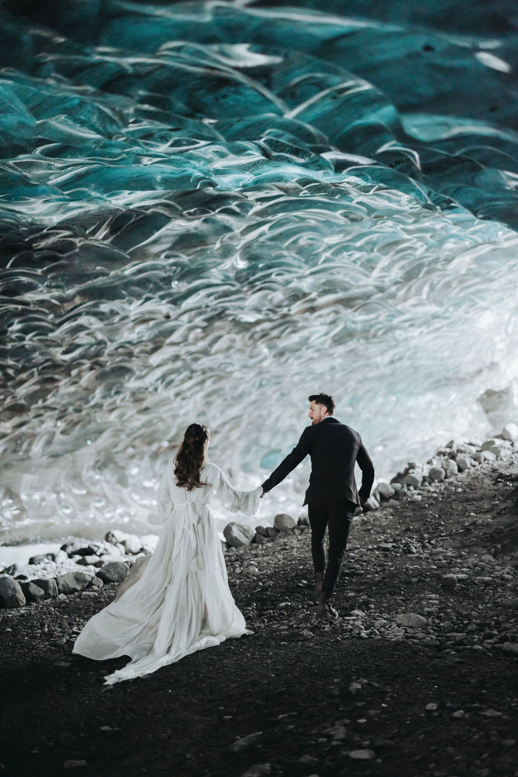 bride and groom walking through ice cave