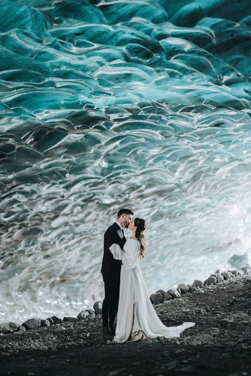 bride and groom posing in front of icecave