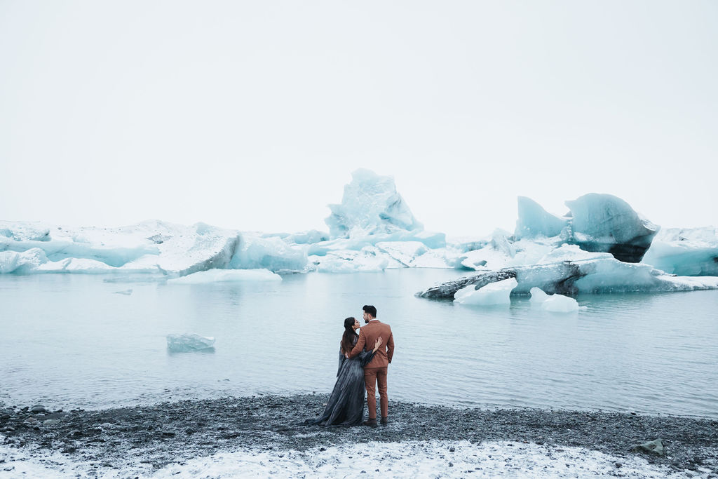 couple portrait standing in front of ice cave lagoon