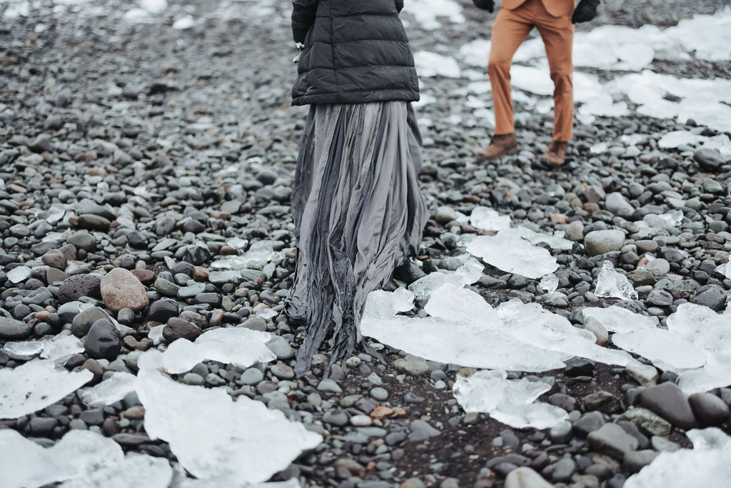 couple portrait standing on icy black rock beach