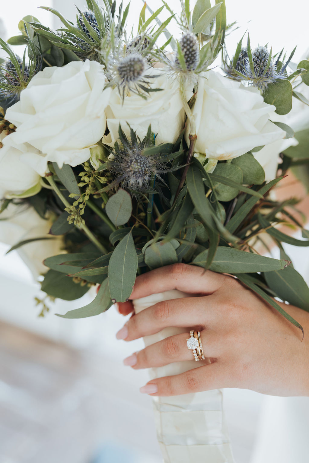 bride holding wedding bouquet with wedding rings