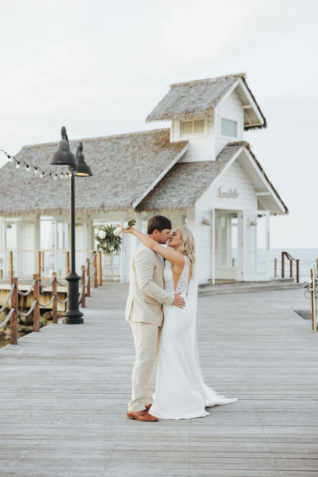 bride and groom kissing on pier