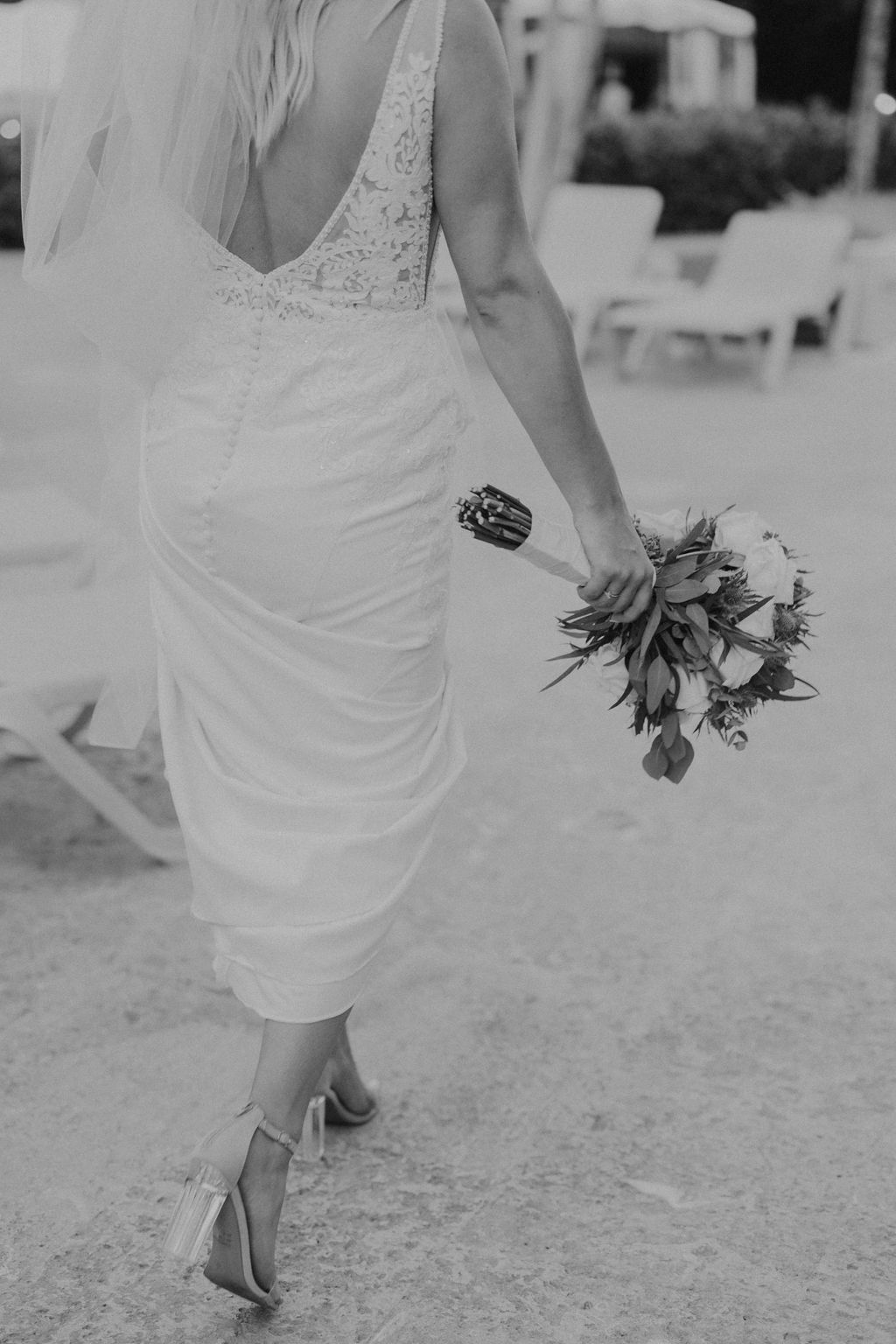 bride holding wedding dress and bouquet