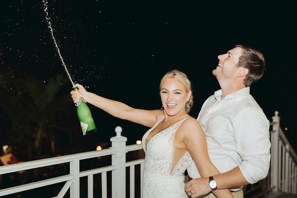 bride and groom popping champagne at reception
