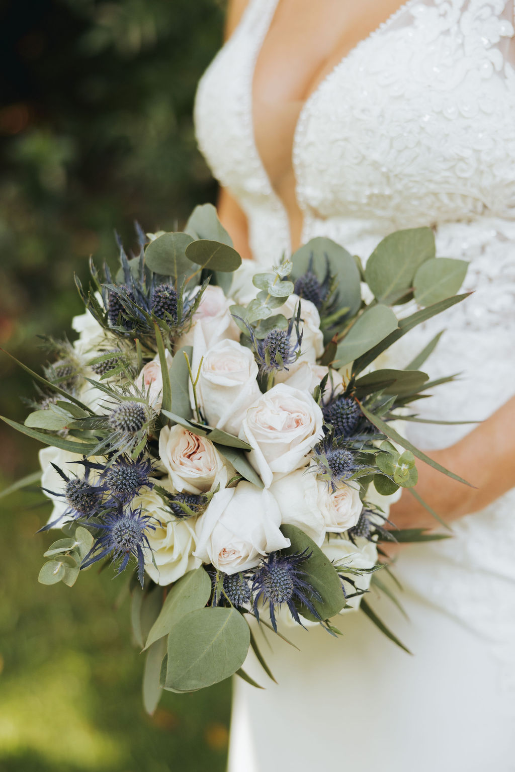 bride holding blue and pink flowers