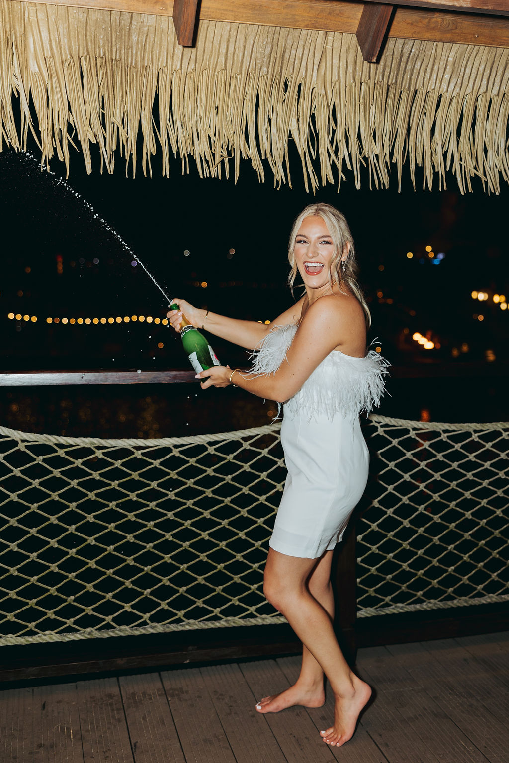 bride popping champagne at rehearsal dinner