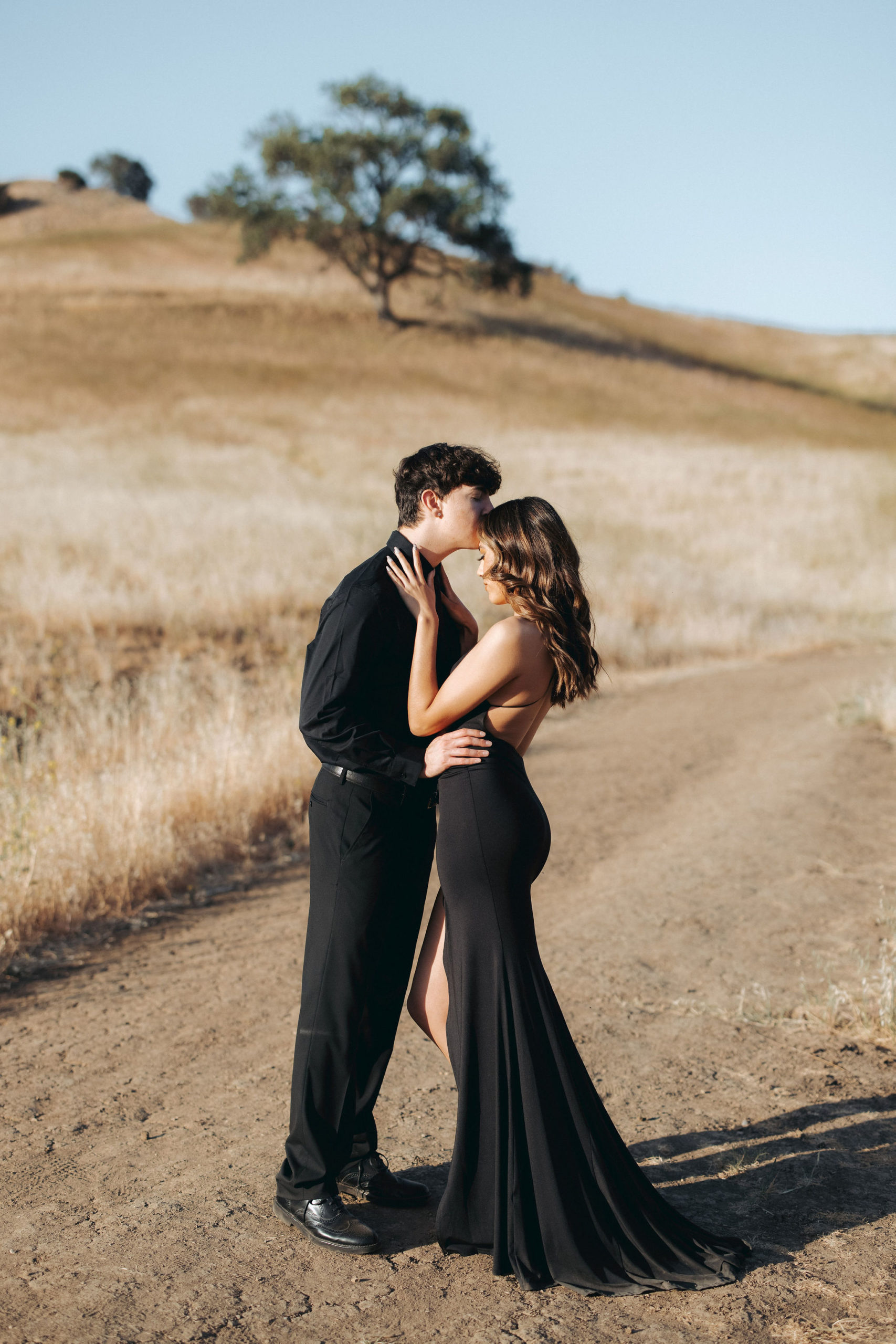 couple kissing on a grassy hill  in Malibu Creek State Park