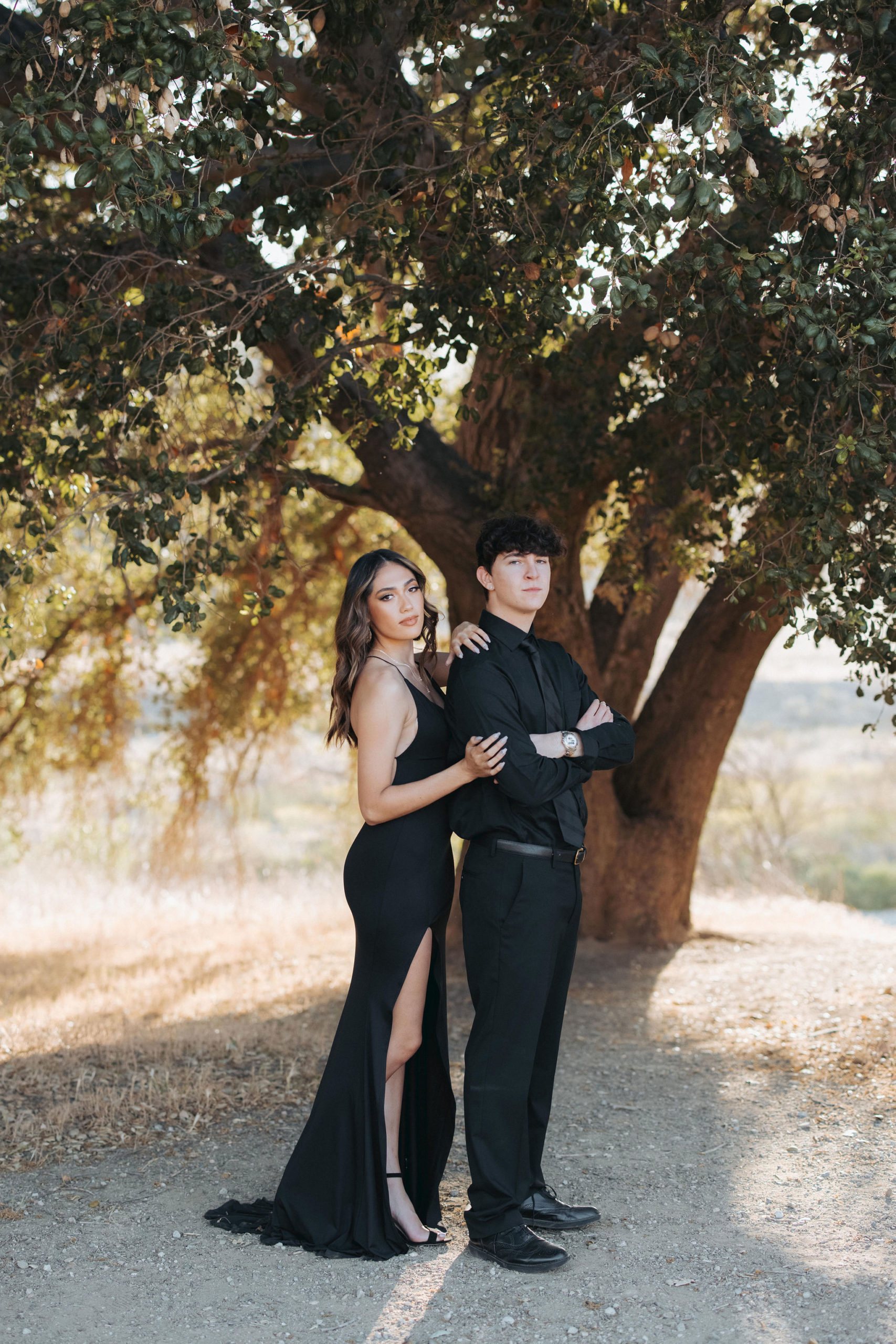 couple posing in front of tree