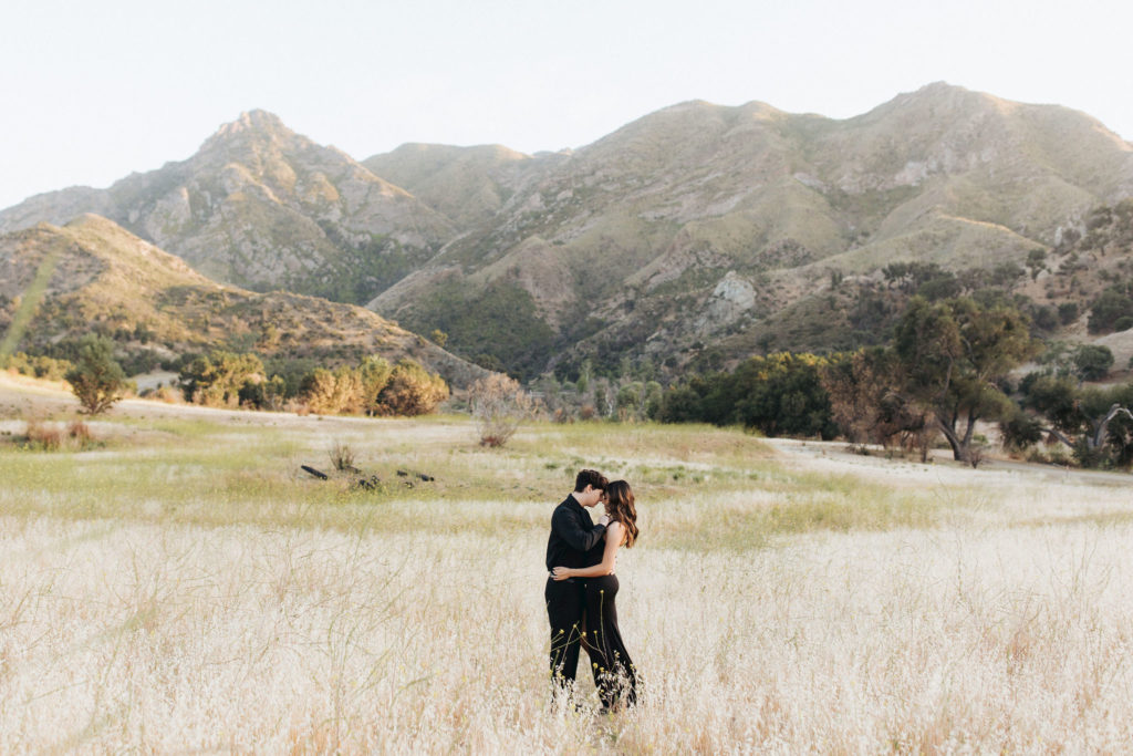 couple kissing in front of mountains in Malibu Creek State Park