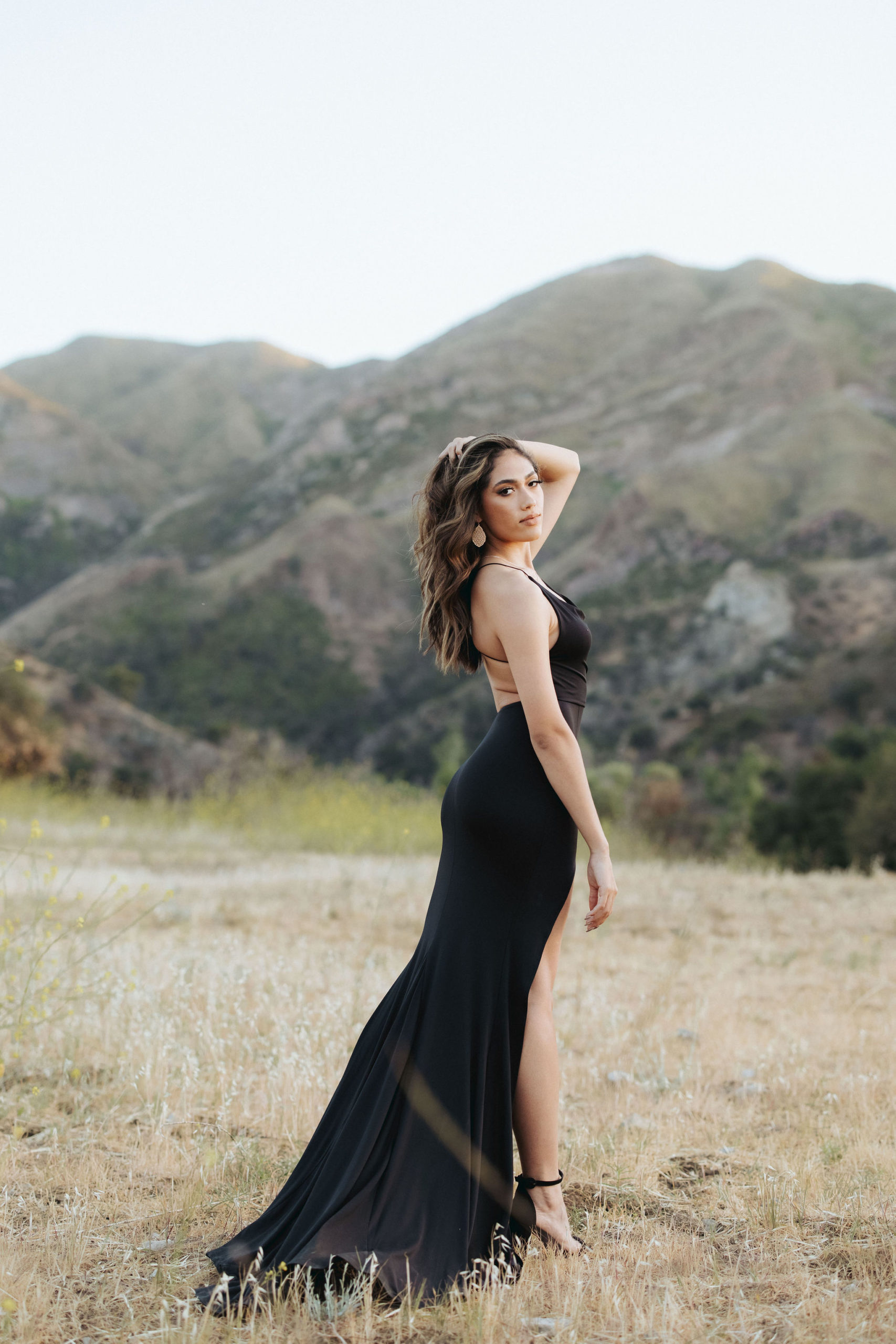 woman in black dress posing in front of mountains in Malibu Creek State Park