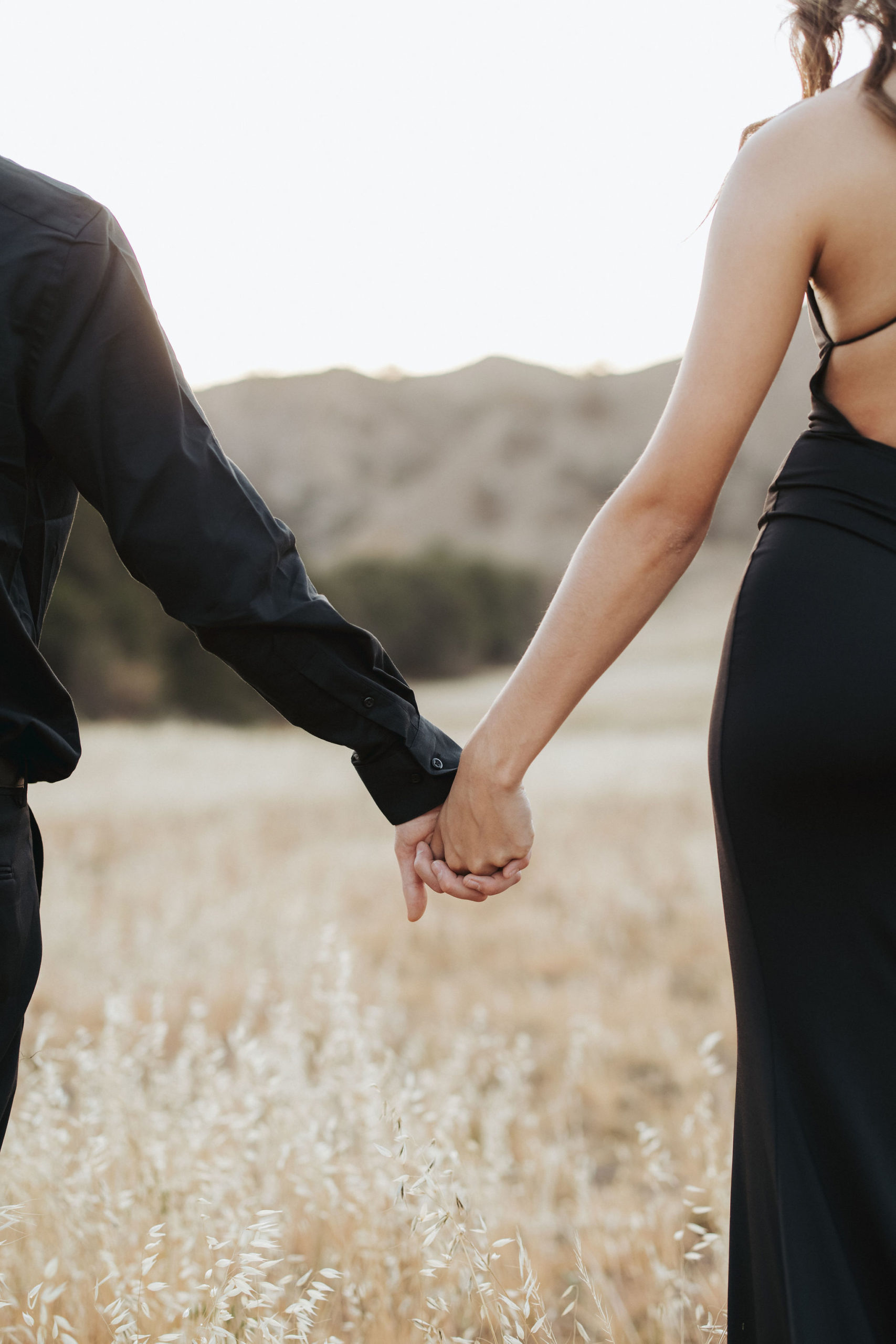 couple holding hands in a field