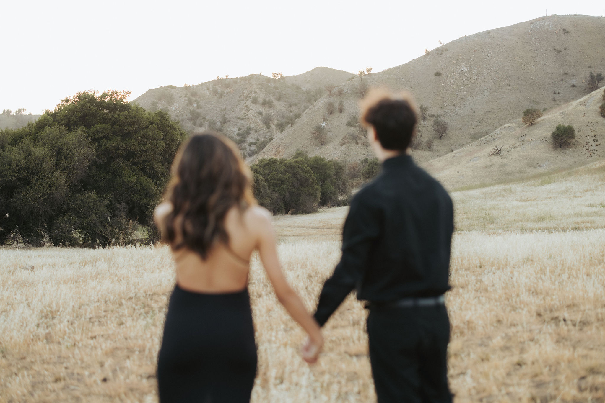couple holding hands in a field in Malibu Creek State Park