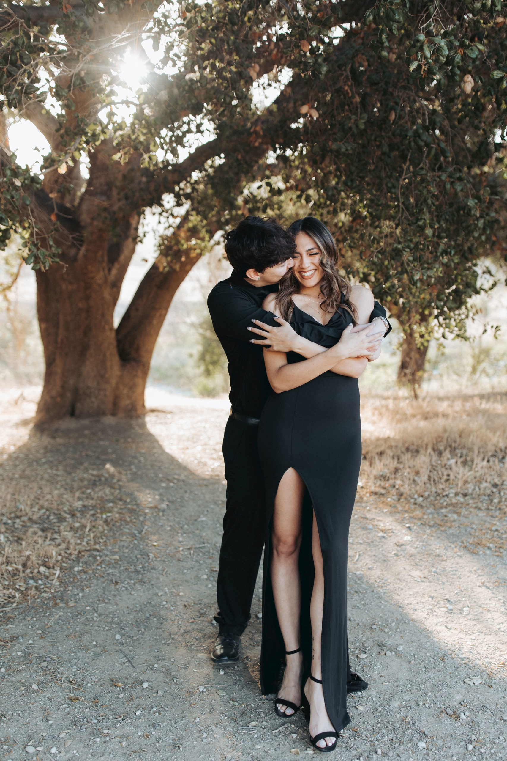 Couple hugging in front of tree in Malibu Creek State Park