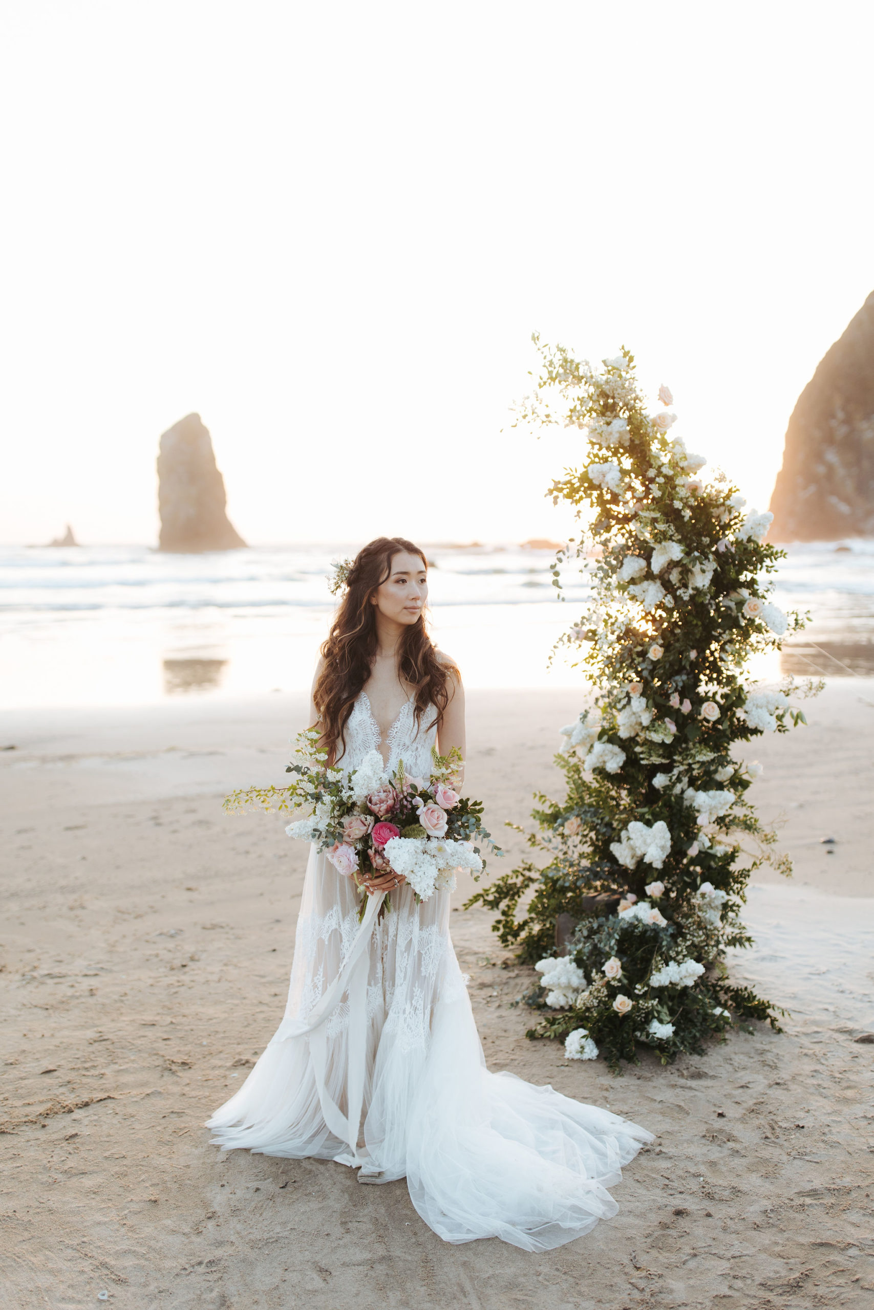 bride portrait on Oregon Coast  beach with flower arch and candles
