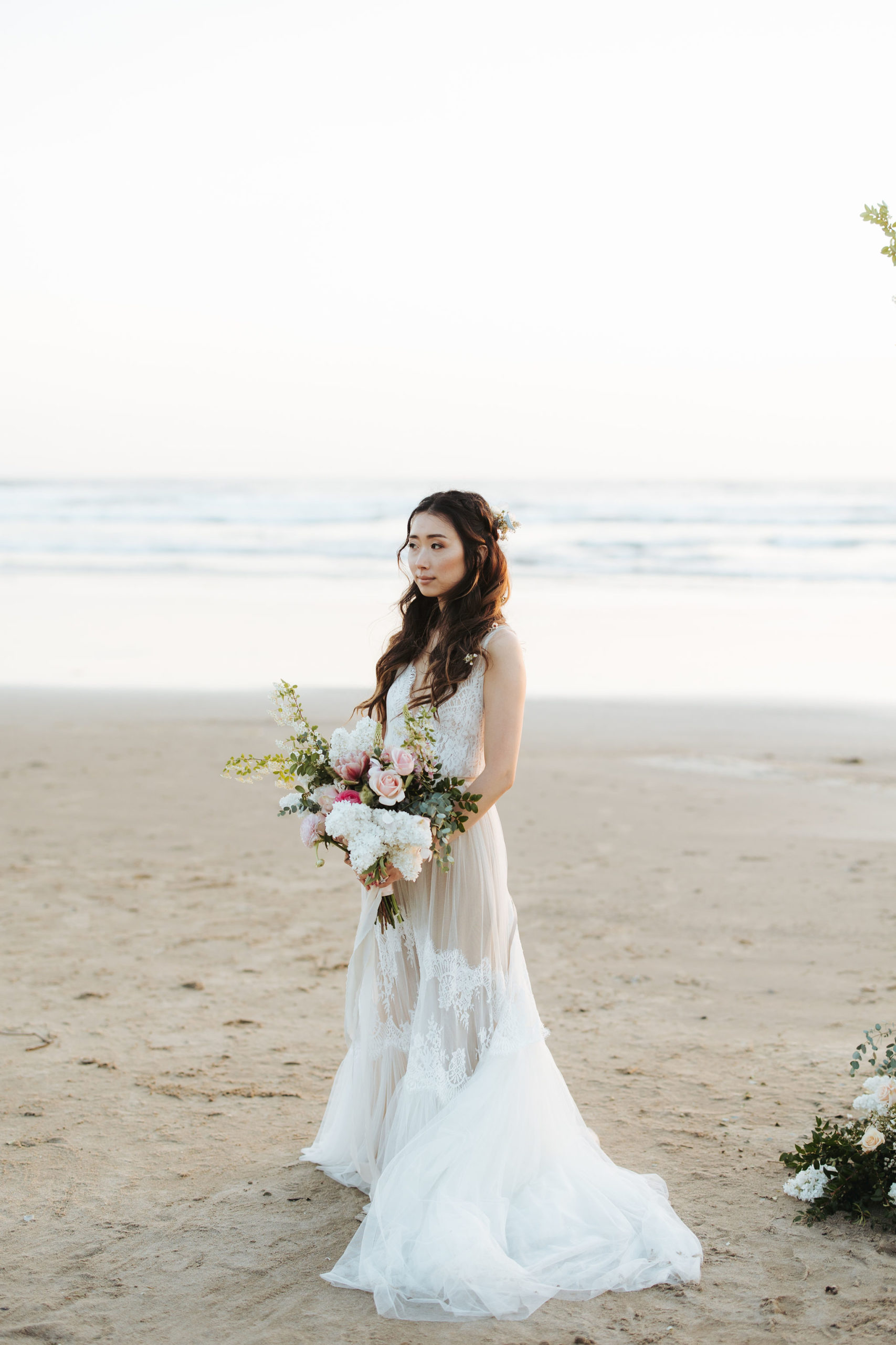 bride portrait on beach with flower arch and candles