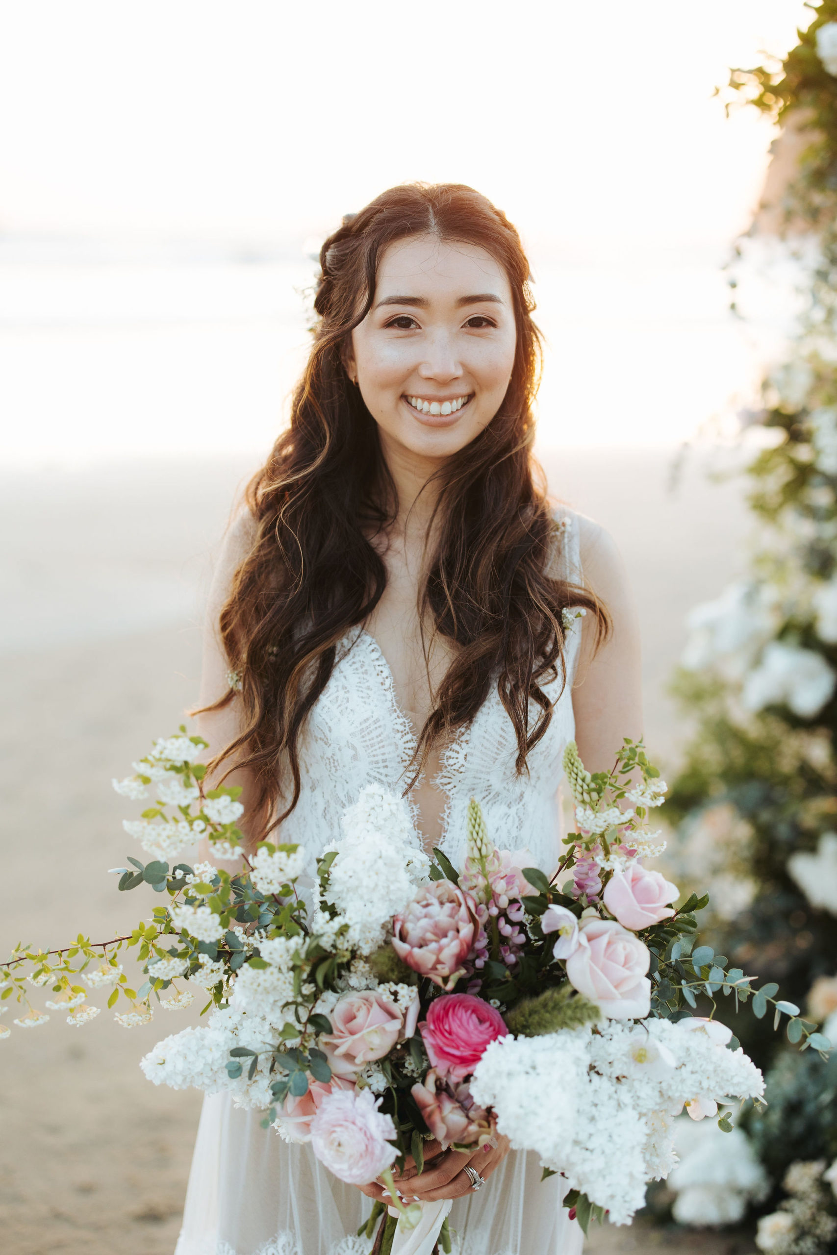 bride portrait on beach with flower arch and candles