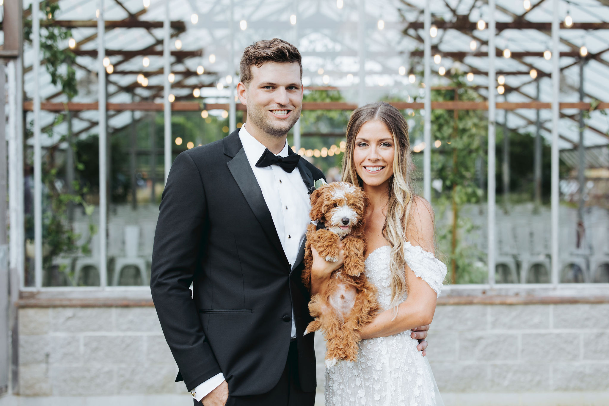 bride and groom holding puppy