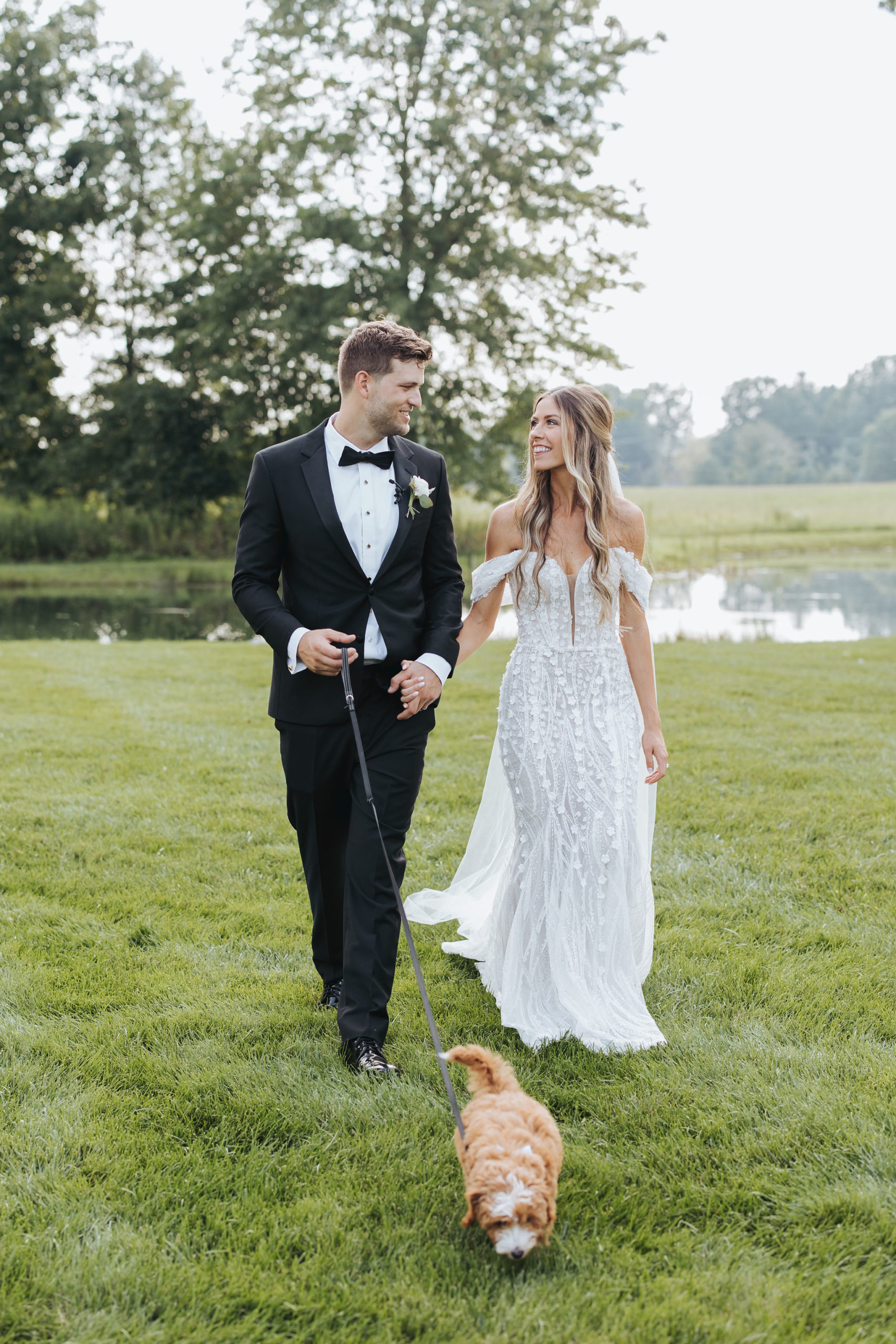 bride and groom walking puppy