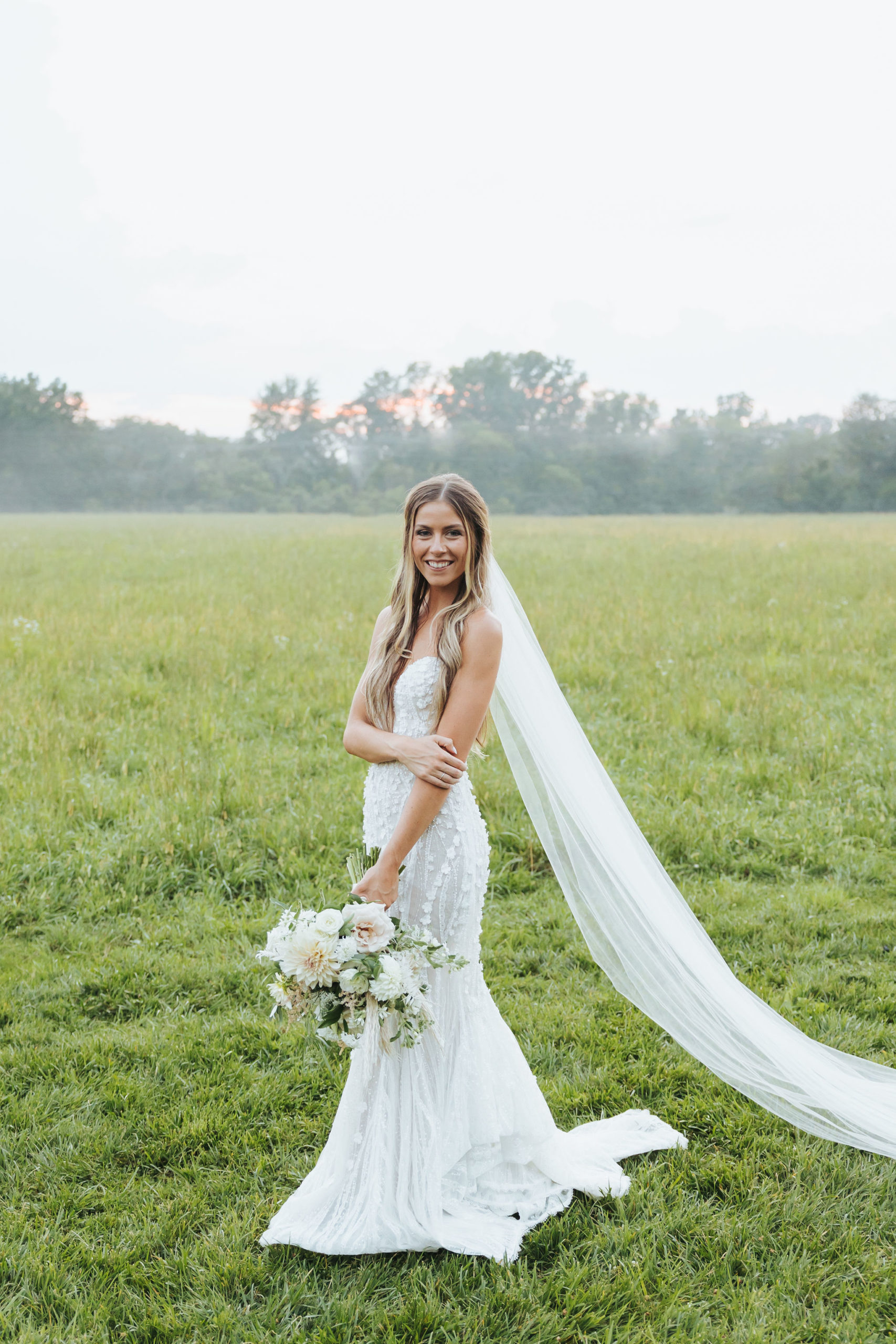 bride in a field at sunset
