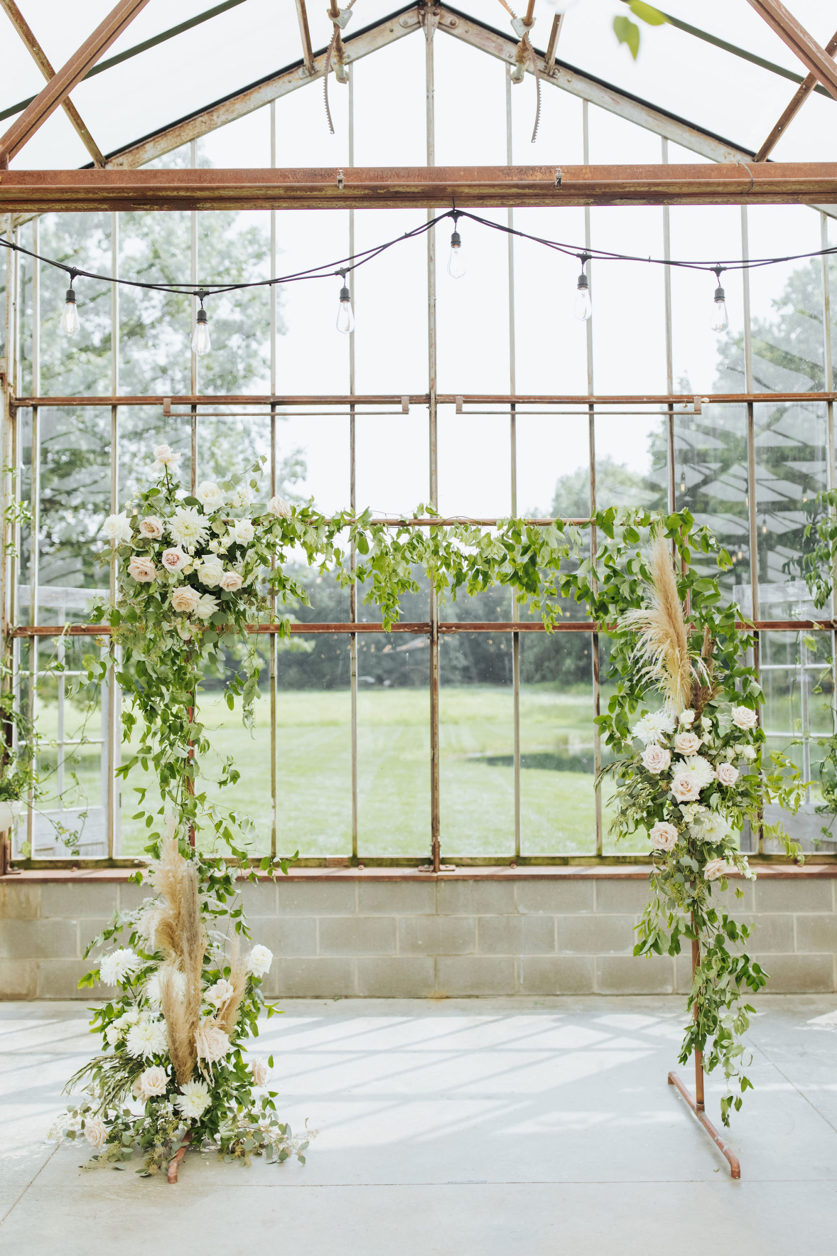 greenhouse wedding venue with floral arch