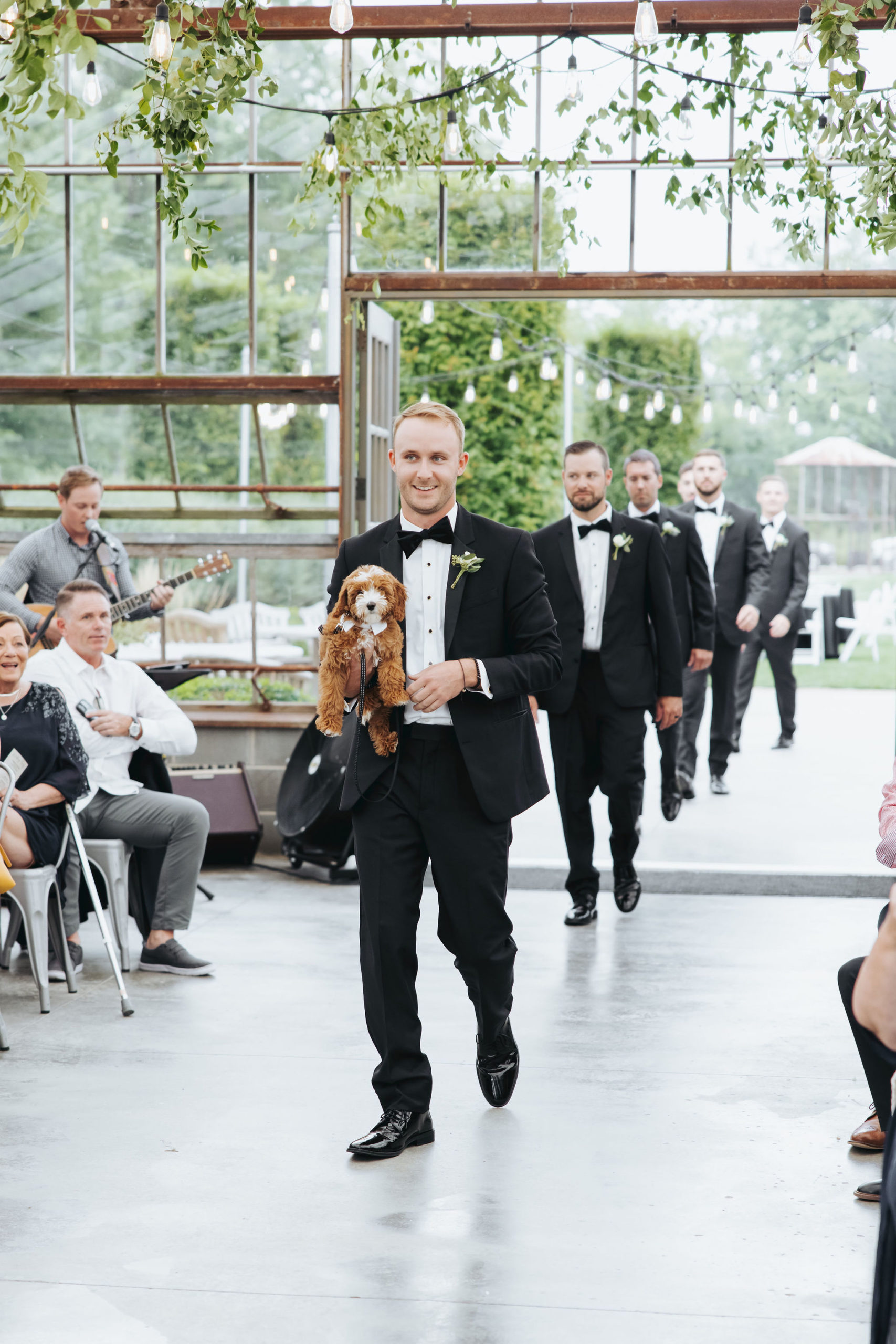 groomsman walking down the aisle with puppy