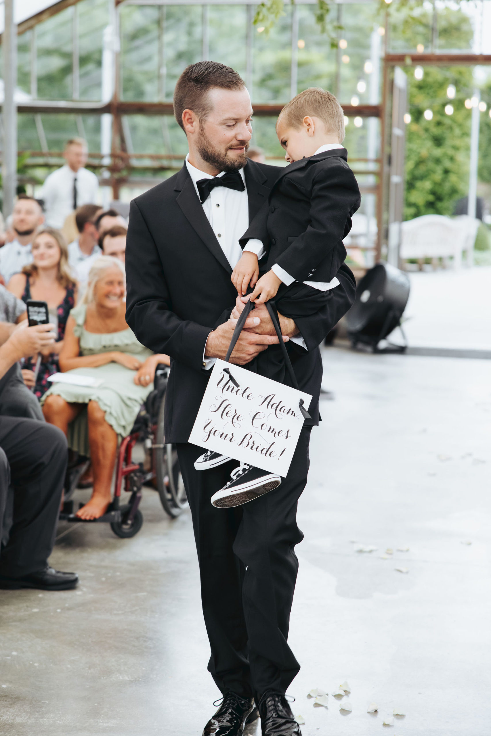 groomsman walking down the aisle with ring bearer