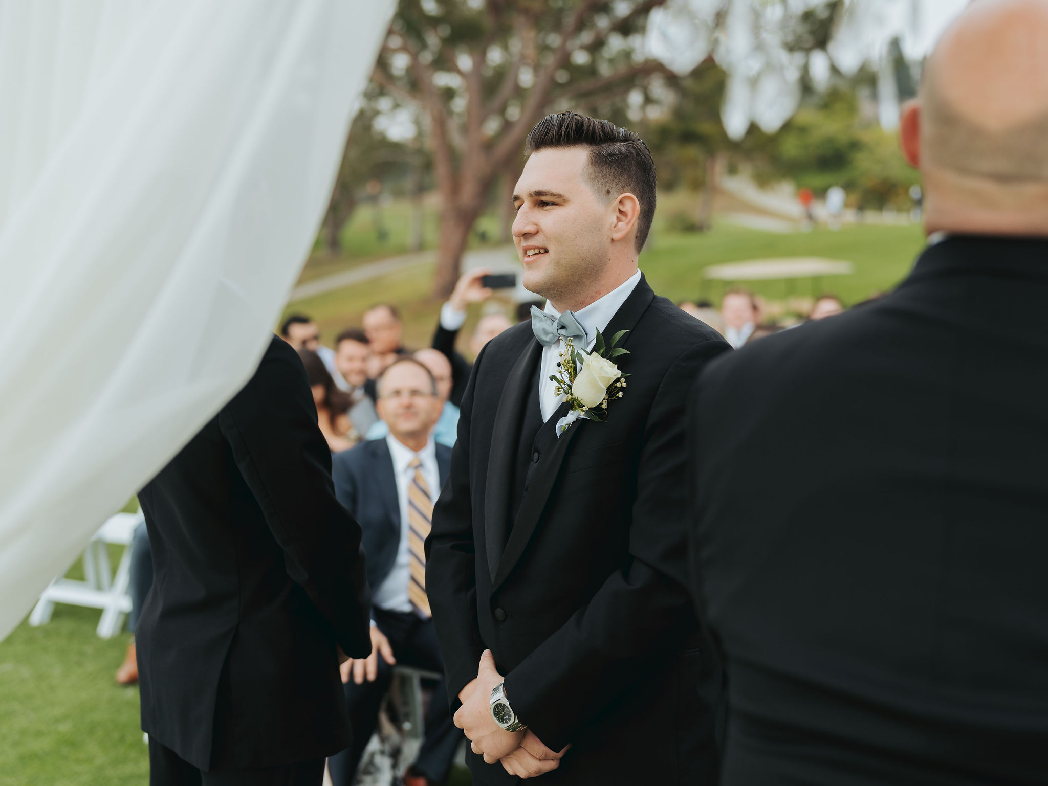 groom standing at the end of the aisle