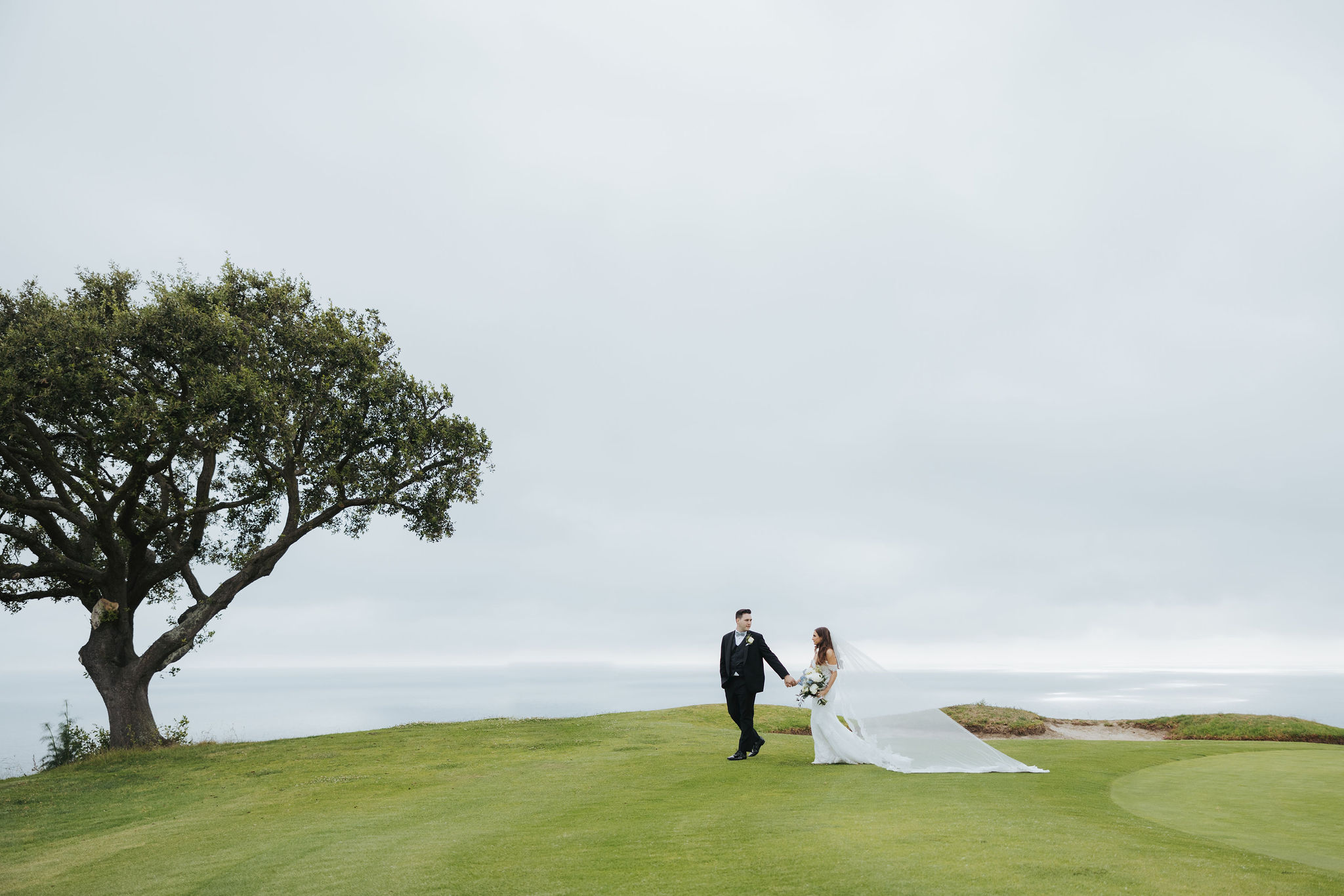 bride and groom walking on a golf course