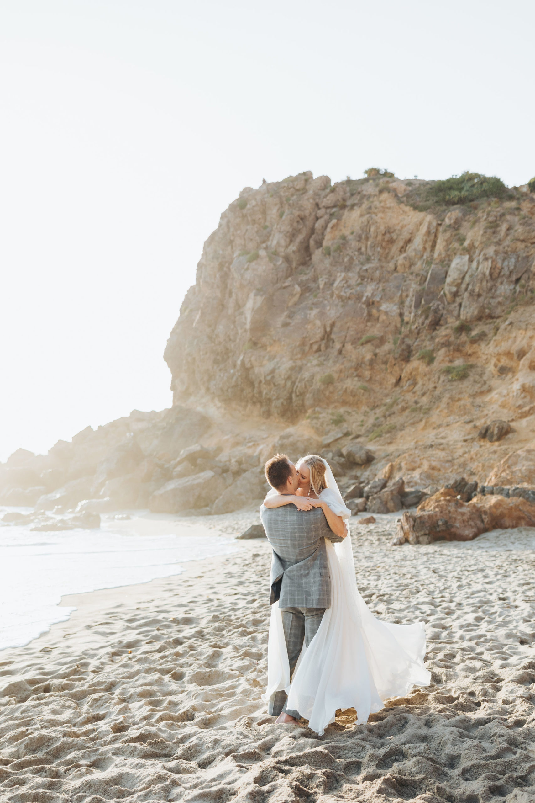 bride and groom kissing on a beach golden hour at Point Dume