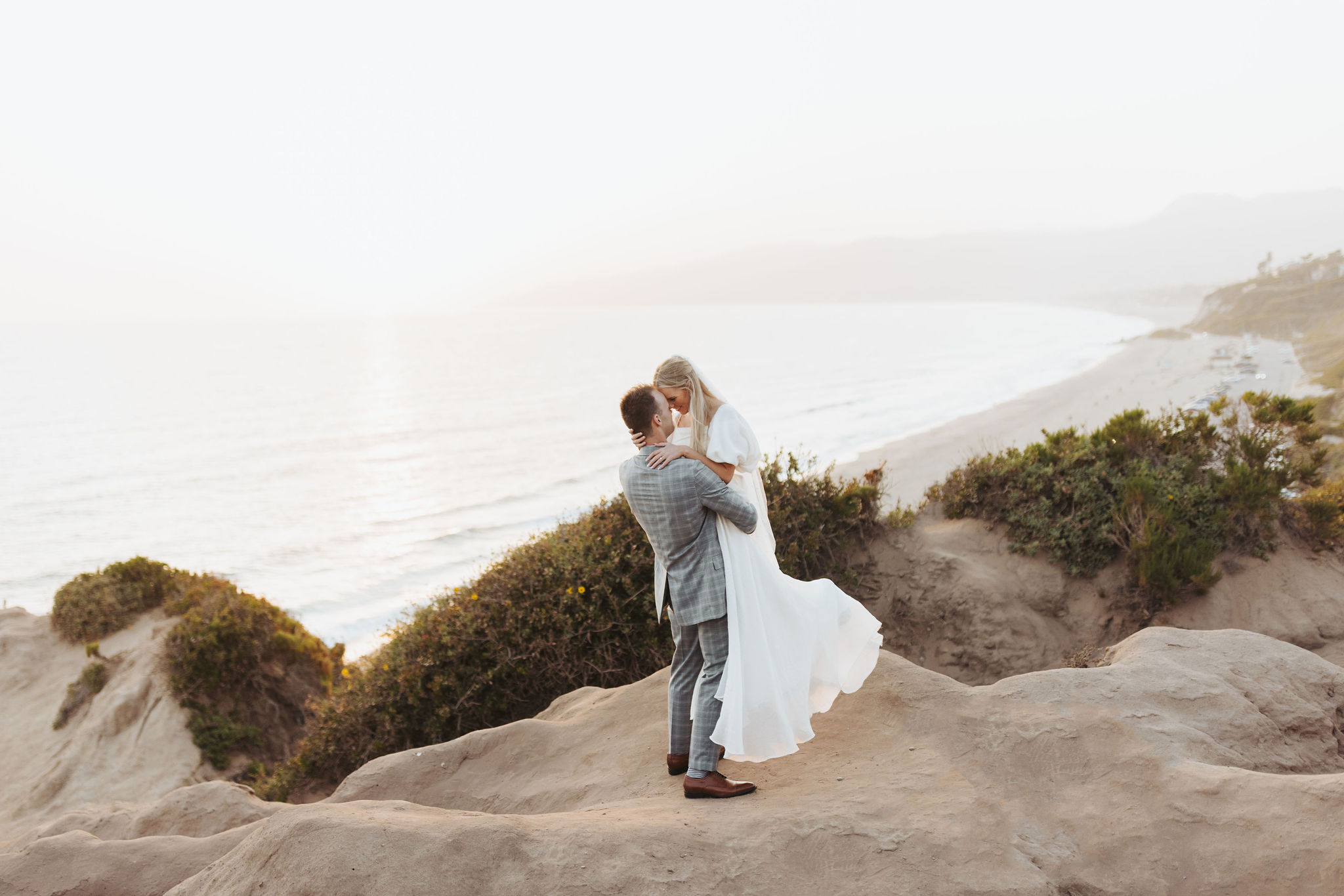bride and groom hugging on a beach at Point Dume